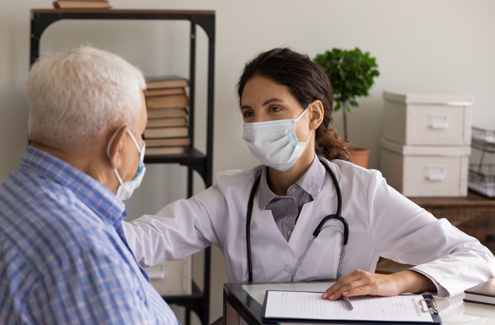 A healthcare professional explaining the Interlocking Finger test with an older adult.
