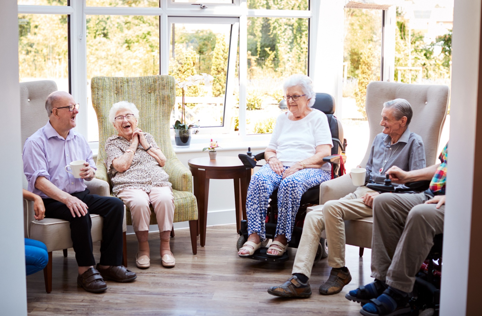 A group of happy seniors sitting around laughing and enjoying each other's company.
