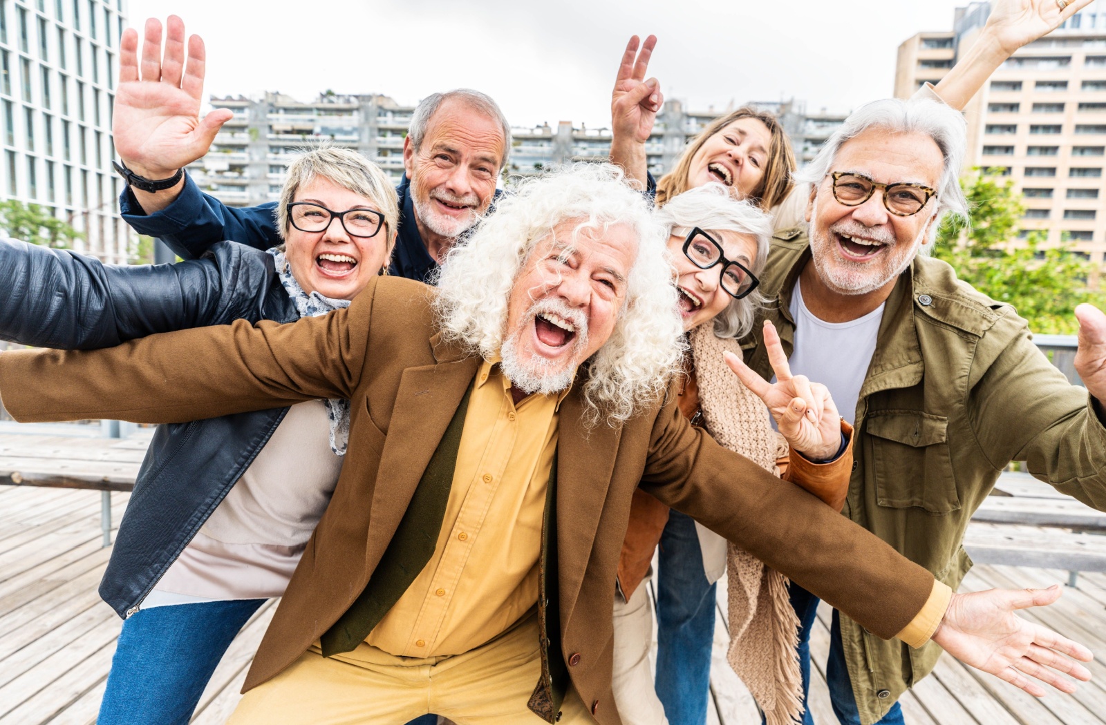 During a day trip into the city, a group of seniors pose for a silly picture to commemorate their friendship and excursion